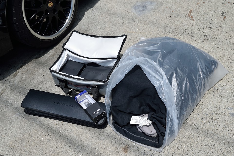 車両に付属のご覧のものもお付けします。左から、ポルシェバック内にエマージェンシーキット、予備バルブ・ヒューズキット、手前が停止表示板、純正シフトノブ、右がポルシェ用ボディカバー。