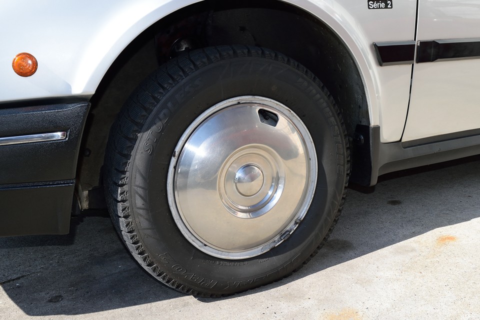 現在、タイヤはご覧のスタッドレスタイヤ（ブリジストンのBLIZZAK、185/70R14）を装着しています。これからの季節には丁度ですね。残山も6分山というところですので当分交換の必要はなさそうです。別途費用にはなりますが、サマータイヤご希望の場合はお気軽にお申し付けくださいませ。