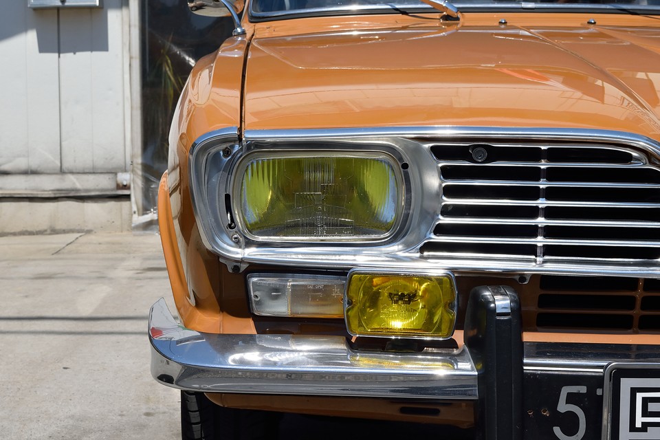 同時代のルノー10と共通のラウンドスクエアのヘッドライトはイエローバルブで決まり！曇りもなく、クリアーな状態です。やっぱ「目」は大事ですからね。ちなみに、ヘッドライトの向かって右上にあるのはボンネットキーシリンダーです。そう、ボンネットはカギで開ける構造なのです。