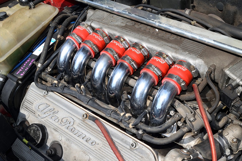 美しさにもこだわった「見せるエンジン」はアルファの魂を感じます。オレカレーシング製の真っ赤なサージホースも◎！クルマ好きを自負される方なら一度はこのV6、経験されることをおススメします。