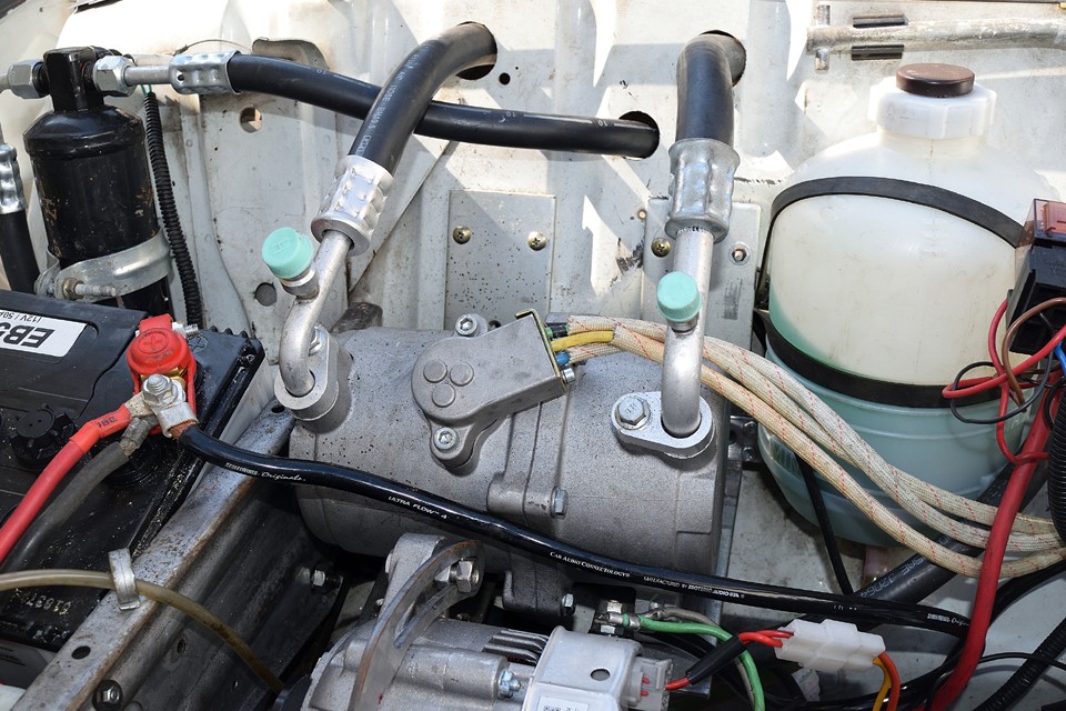 そしてこれが肝心の電動コンプレッサー！ご覧の通りエンジンから繋がるベルトは無く、配線が繋がっているだけなのです。キャトルはスペース的に余裕があったのでエンジンルーム内に設置出来ましたが、配管の取り回しは、設計しながらの作業なので、それなりの苦労がありました。