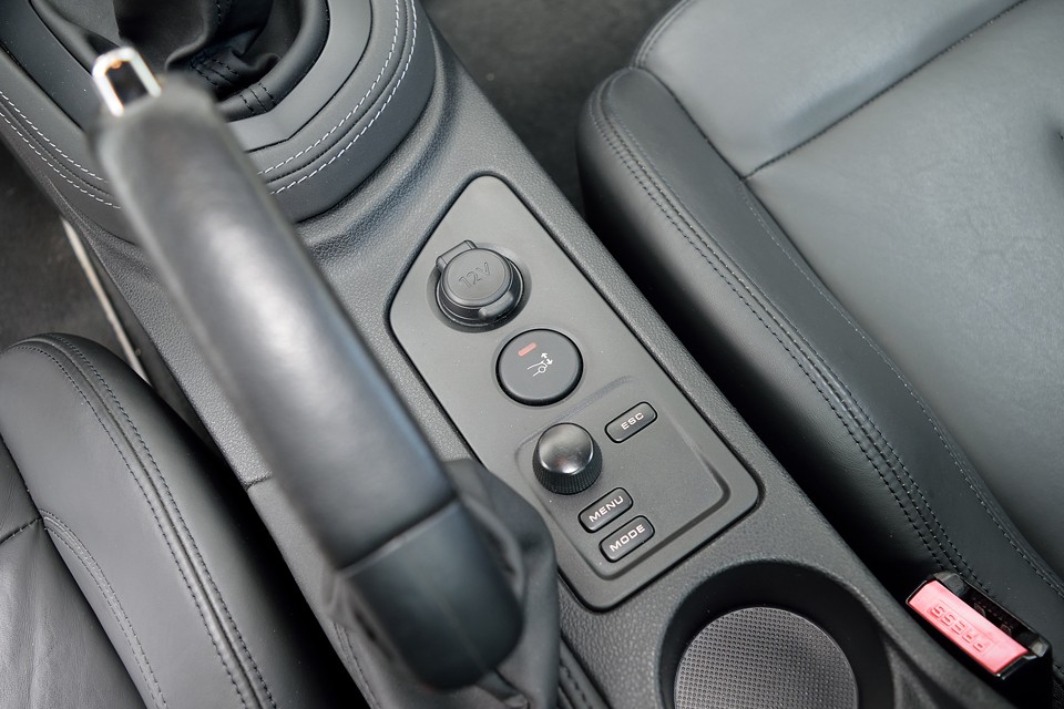 サイドブレーキ横には、12V電源、インフォメーションディスプレイの操作ボタンに加え、リアスポイラーを手動で可変させるボタンがあります。